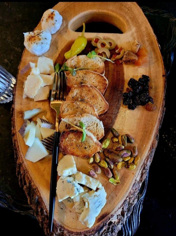 A charcuterie board with cheese, toast, nuts and dried fruit