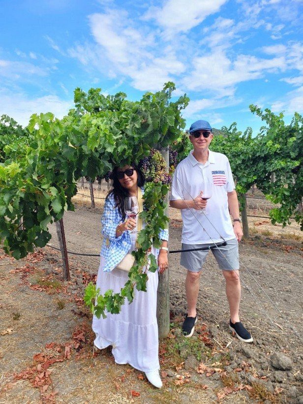 Gloria standing among the vines on one of her wine journeys